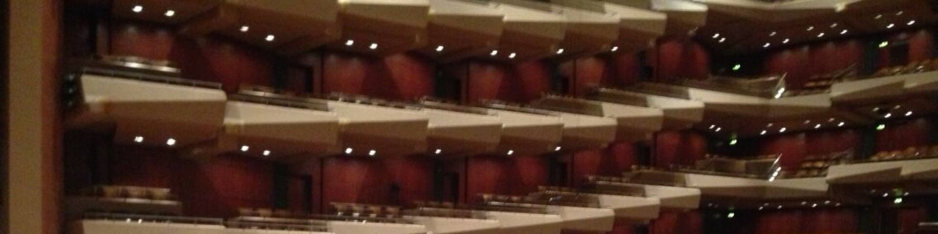 A large concert hall with musicians and orchestral instruments.