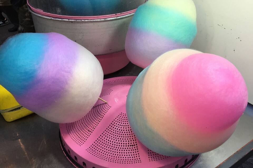 A collection of colorful, spherical objects on a pink perforated stand.
