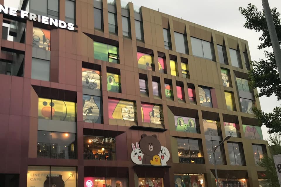 A building with colorful windows and signs for LINE FRIENDS and LAGRILLA.