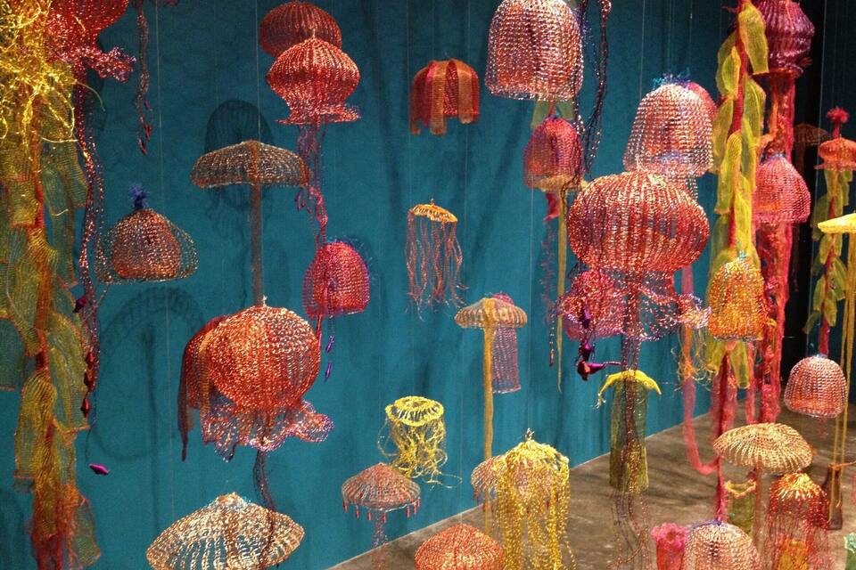 A display of colorful, textured sculptures resembling jellyfish and mushrooms.