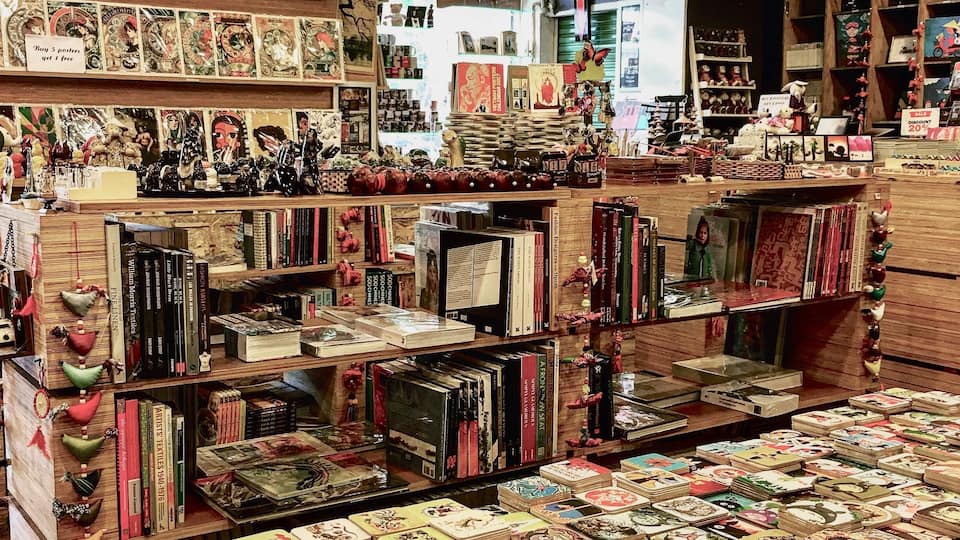 Una librería con estanterías llenas de libros y diversos objetos decorativos.