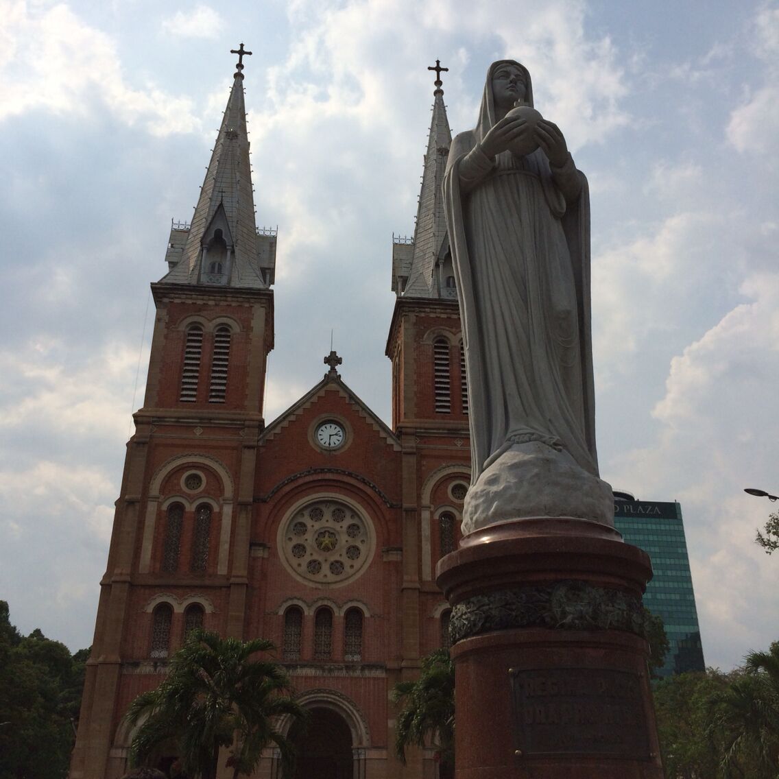 A church with two spires and a statue in front.