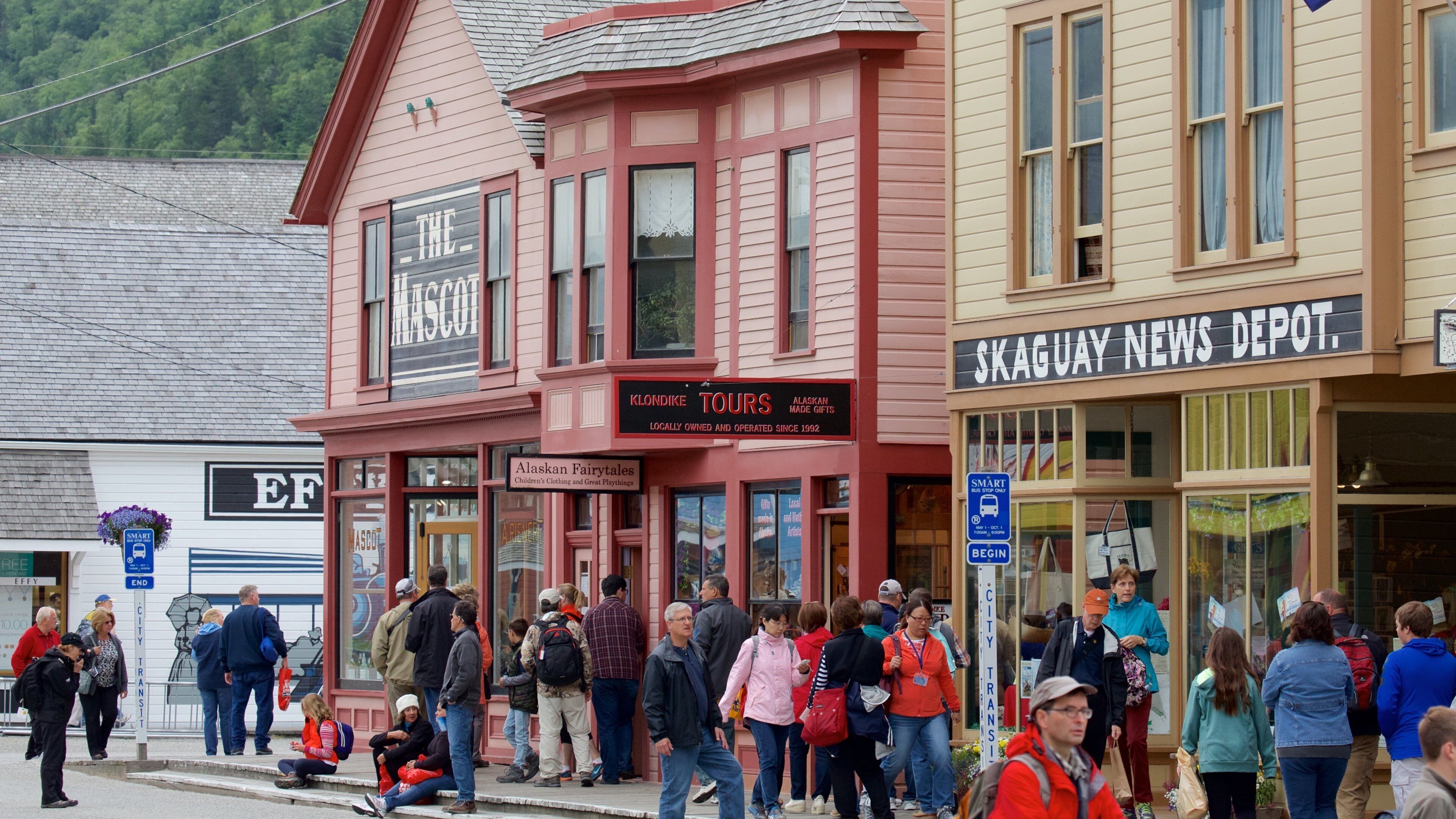 A busy street with a red building labeled 'The Mascot' and 'Klondike Tours'.