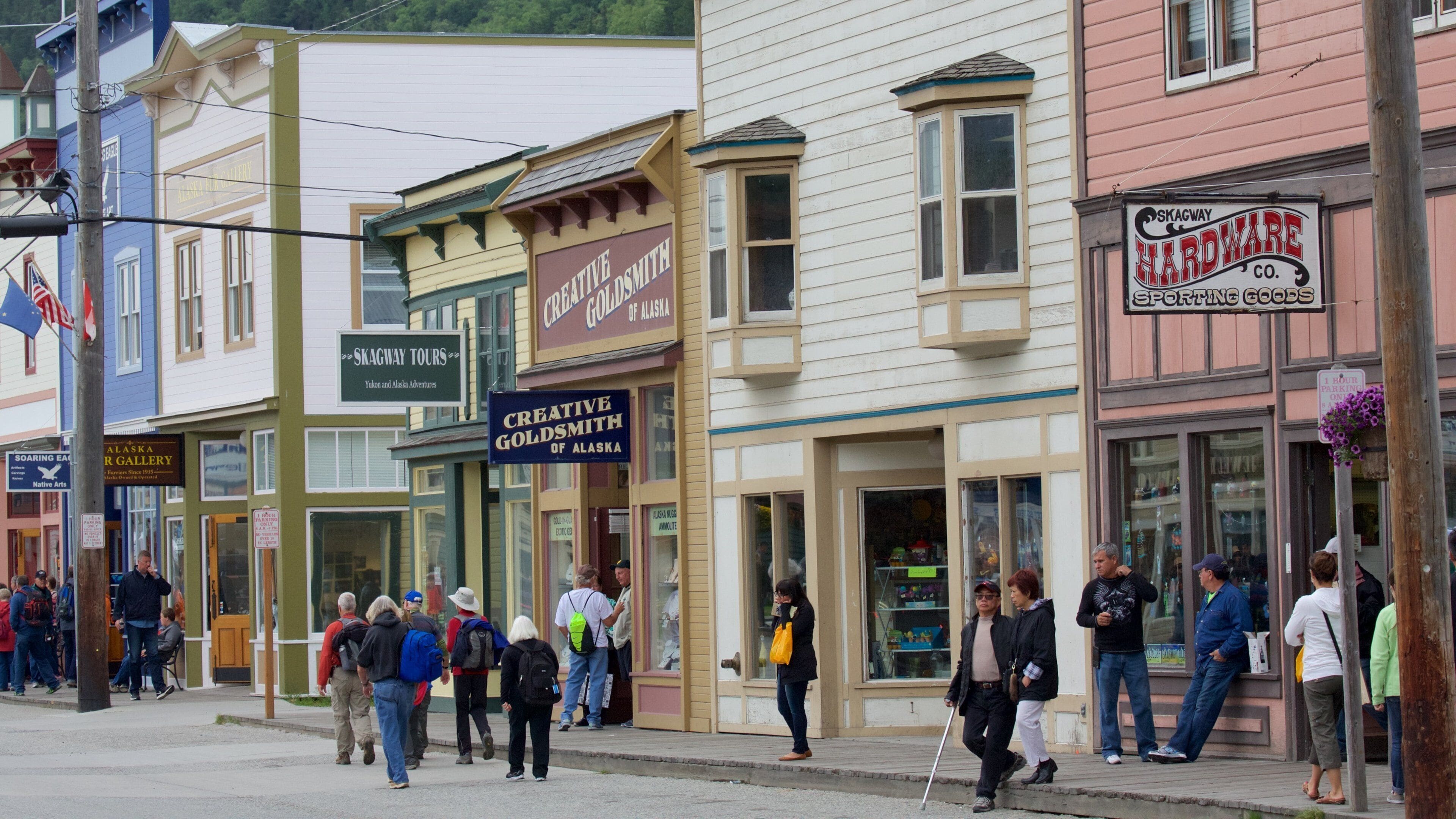 A street lined with various shops, including a hardware store and a gallery.