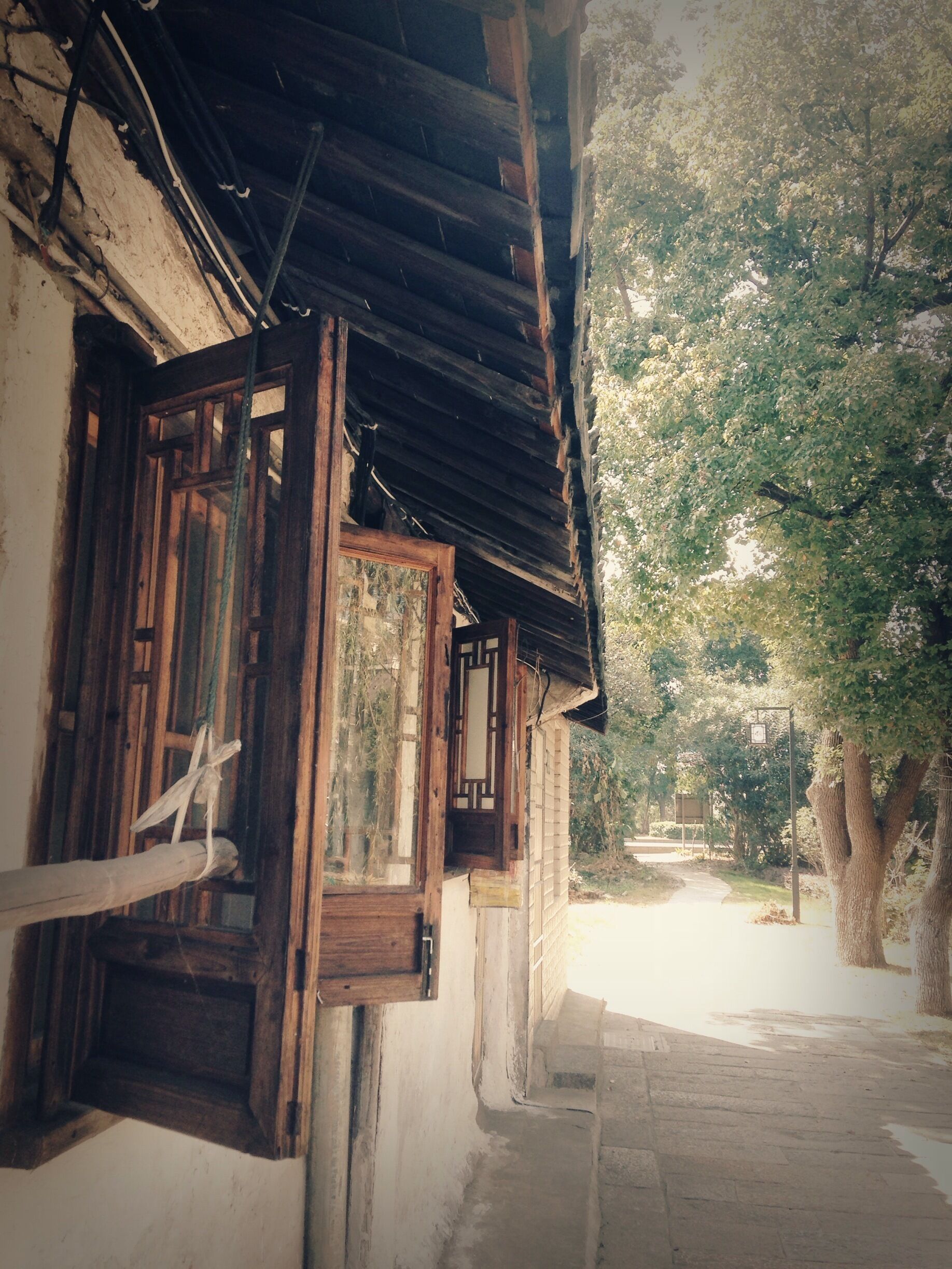A traditional wooden building with a sloped roof, a wooden door, and a window with a decorative frame.