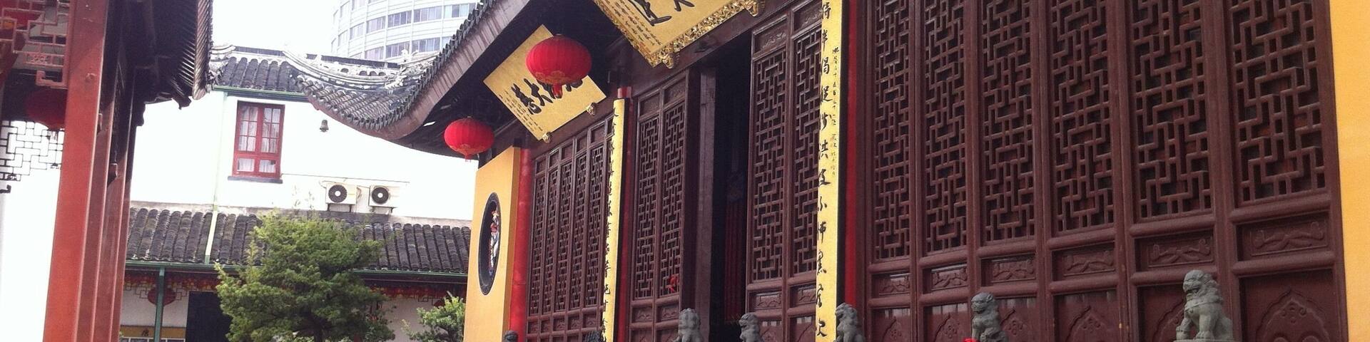 A traditional Chinese building with ornate wooden doors and red lanterns.