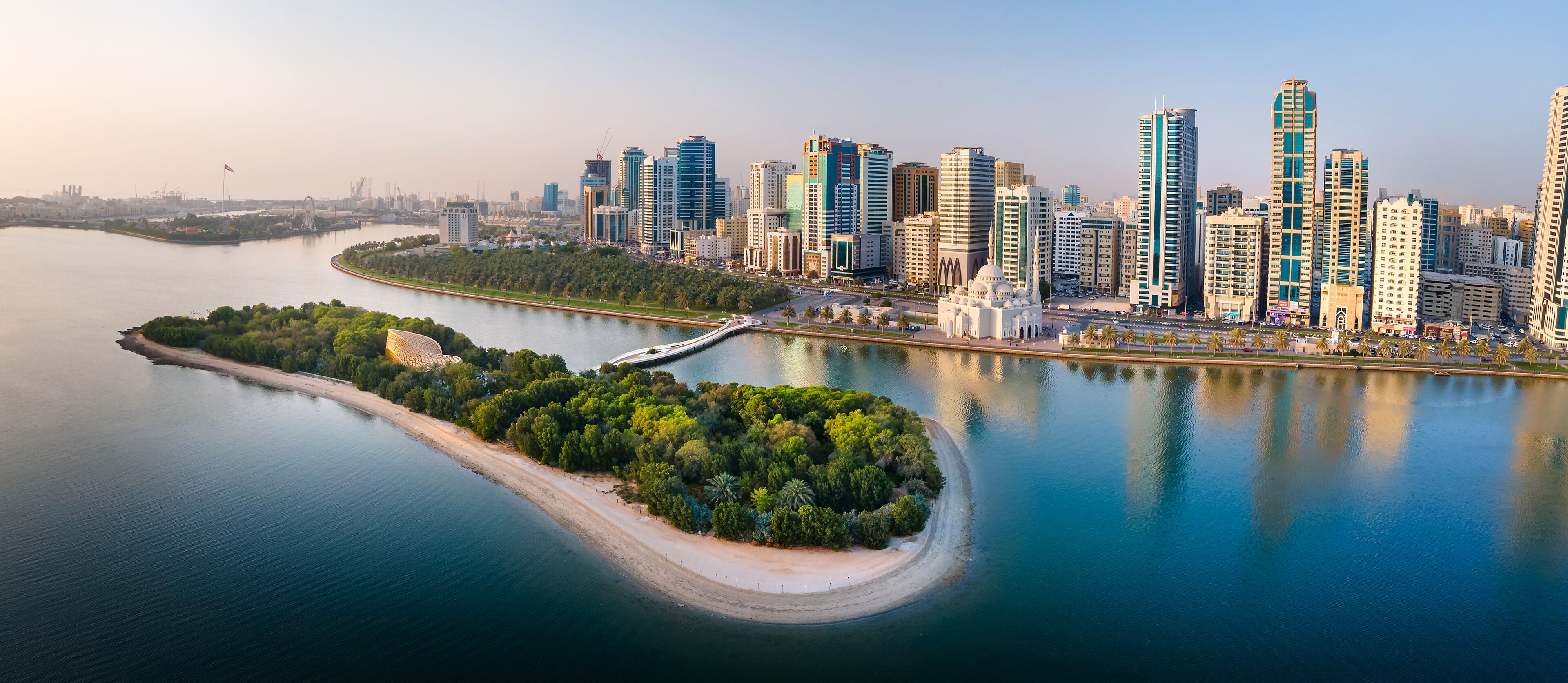 Sharjah aerial panorama above Al Noor island and mosque and downtown rising above Khalid lake