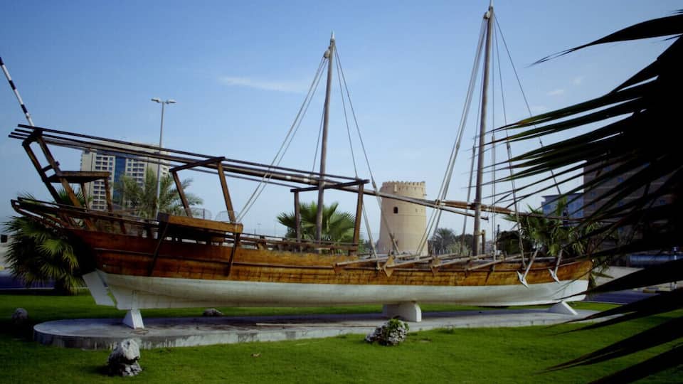 Ancient Sharjah UAE, old boat with an ancient fort in the background