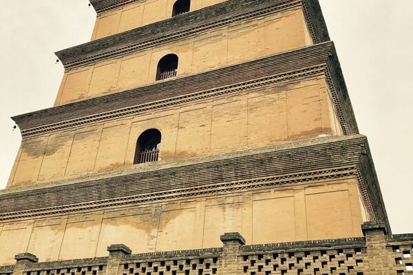 A multi-tiered tower with a brick base and a series of arched openings on each level.