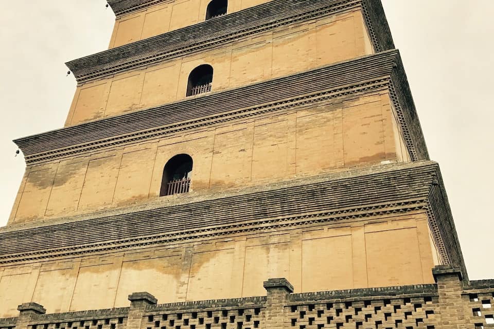 Ein mehrstöckiger Turm mit Backsteingrundlage und einer Reihe von Rundbögen auf jeder Ebene.