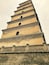 Een meerlaagse toren met een fundering van baksteen en een reeks gewelfde openingen op elk niveau.