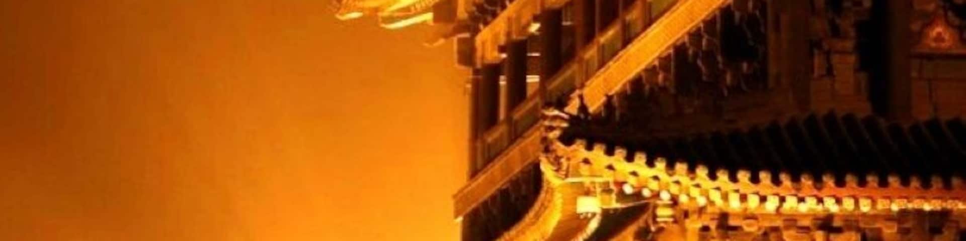 A traditional Chinese building with ornate rooflines and illuminated details.