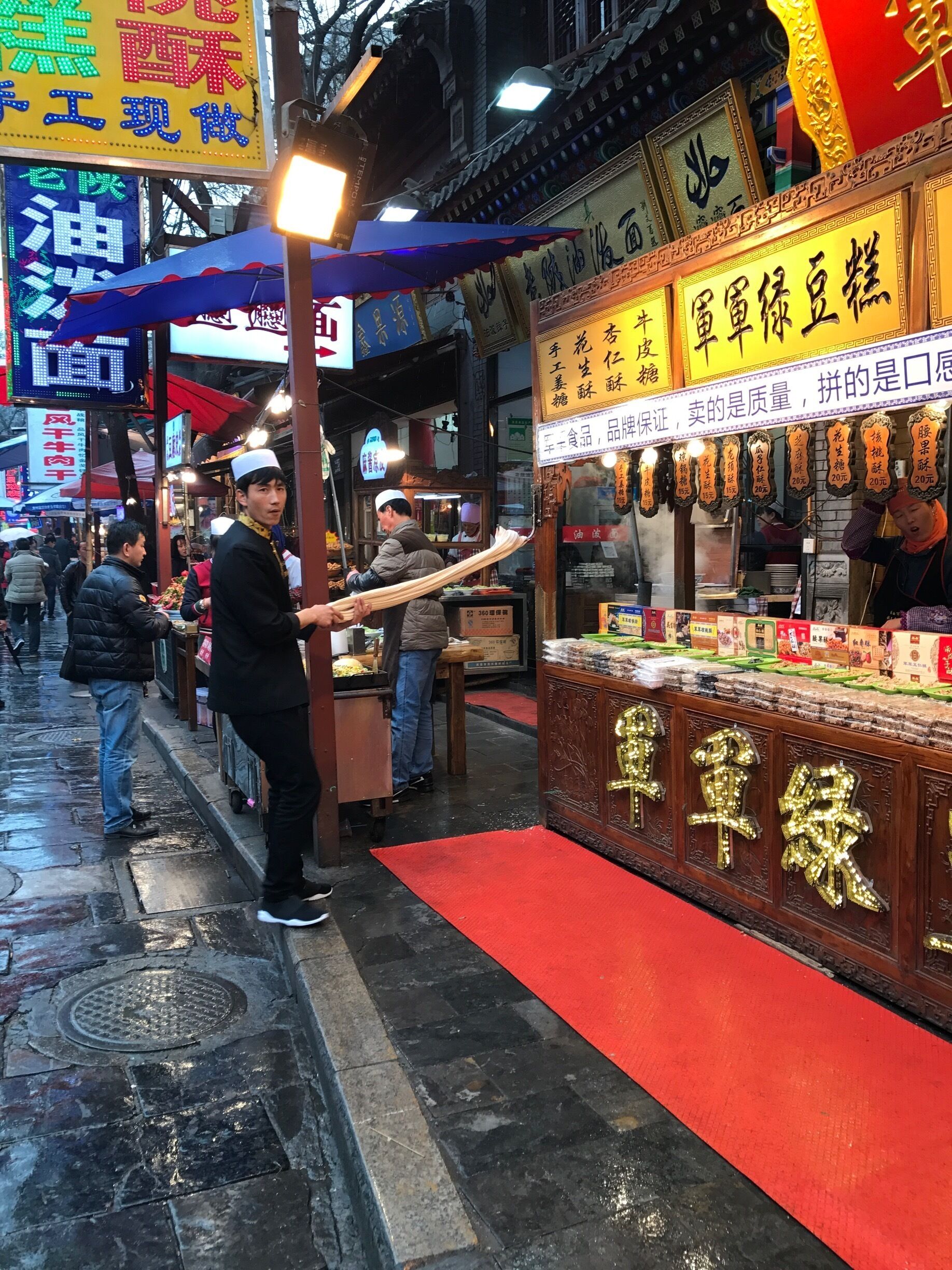 A street market with food stalls, including one with a sign in Chinese characters.