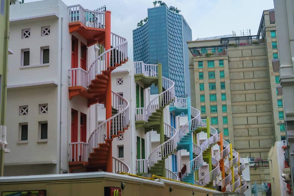 Une rangée de bâtiments colorés, dotés d’escaliers en colimaçon et de balcons.