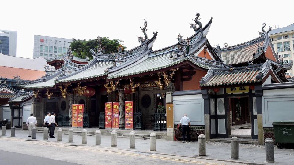 A traditional Chinese building with ornate roofs and statues.