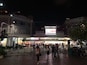 A busy street scene at night with a prominent 'BUGIS STREET' sign and illuminated storefronts.