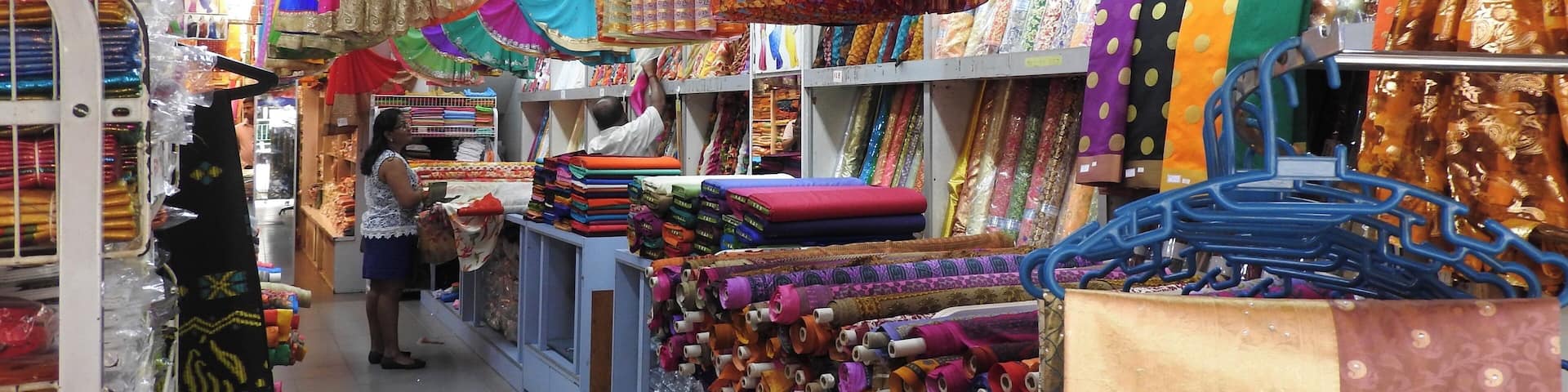 A fabric store with colorful fabrics and rolls of thread.
