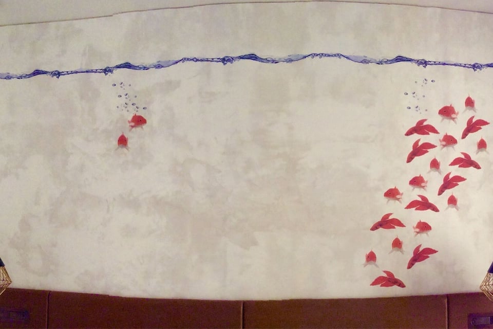 A wall with a mural of fish and bubbles.