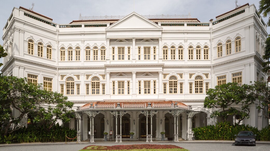 A large white building with a symmetrical facade, columns, and a central entrance with a tiled roof.