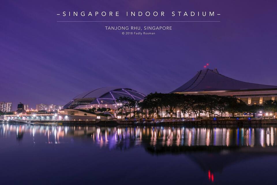 The Singapore Indoor Stadium at dusk with its distinctive dome and adjacent mountain-like structure.