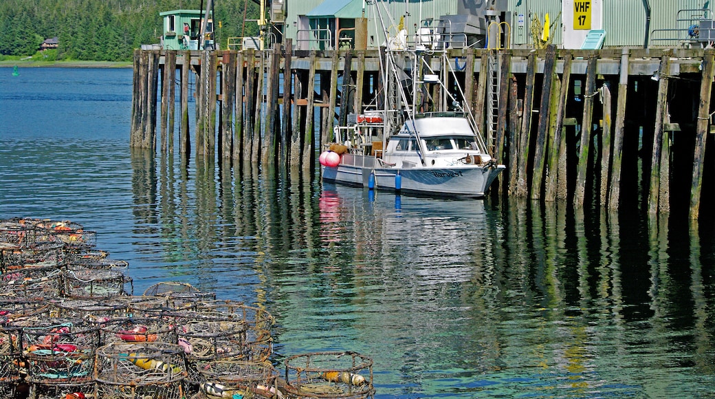 View of dock, fishing boat and stack of fishing traps.