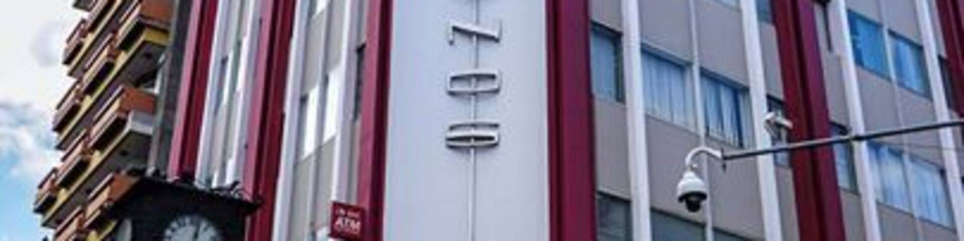 A multi-story building with a prominent vertical sign and a curved entrance.