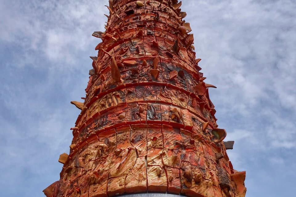 A tall, cylindrical structure with intricate carvings and a spiked design.