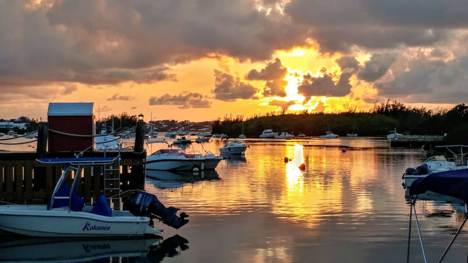 A marina with boats docked during sunset.