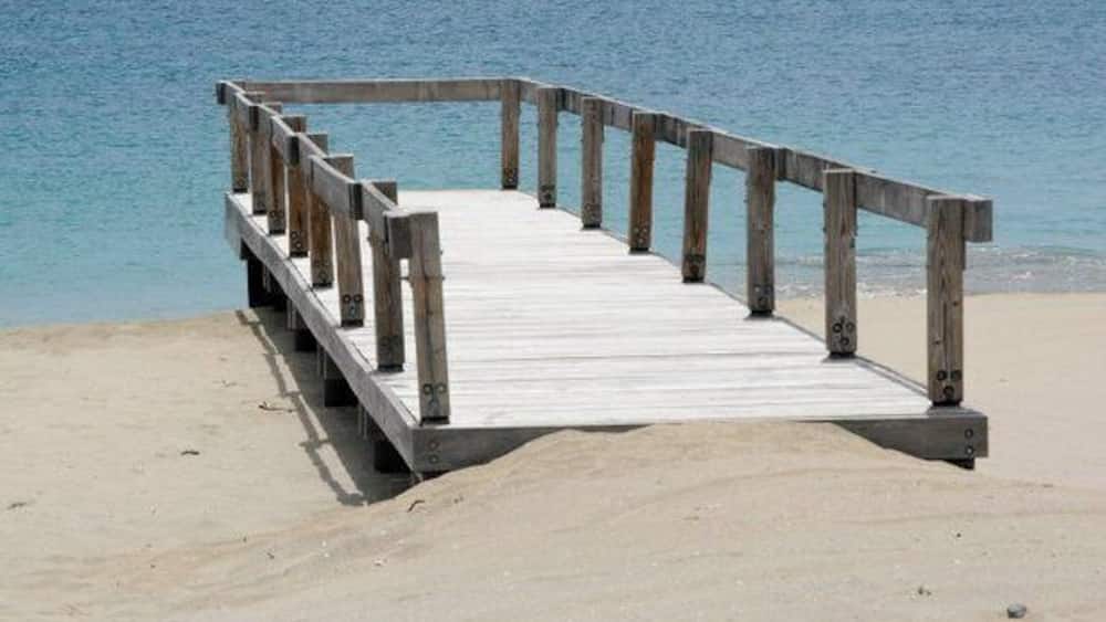 Une jetée en bois s’étendant sur une mer calme.