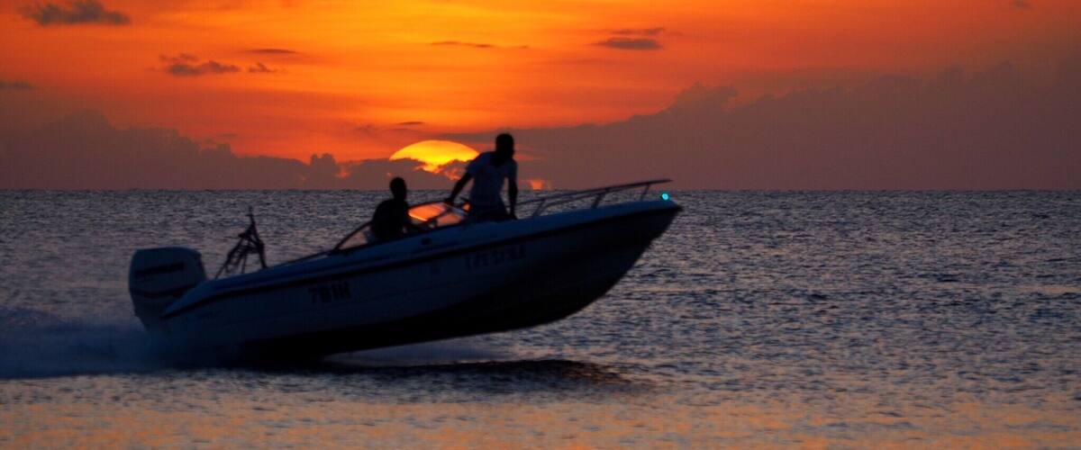 A boat on the ocean during sunset.