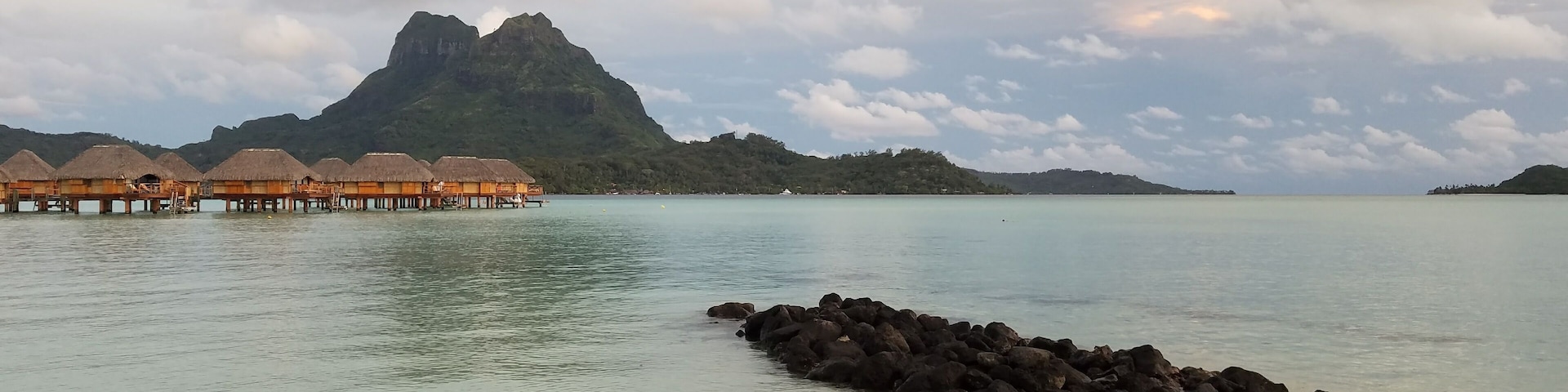 The view of Mt. Otemanu from our resort was amazingly beautiful!! Every picture shot that we took on the resort was picture perfect! It was dusk, and there were crabs crawling all along the rock ledge going into the water. The over water bungalows in the distance were everything that we had imagined to be with fishes swimming right underneath that we can view from inside. ❤#BeachTips