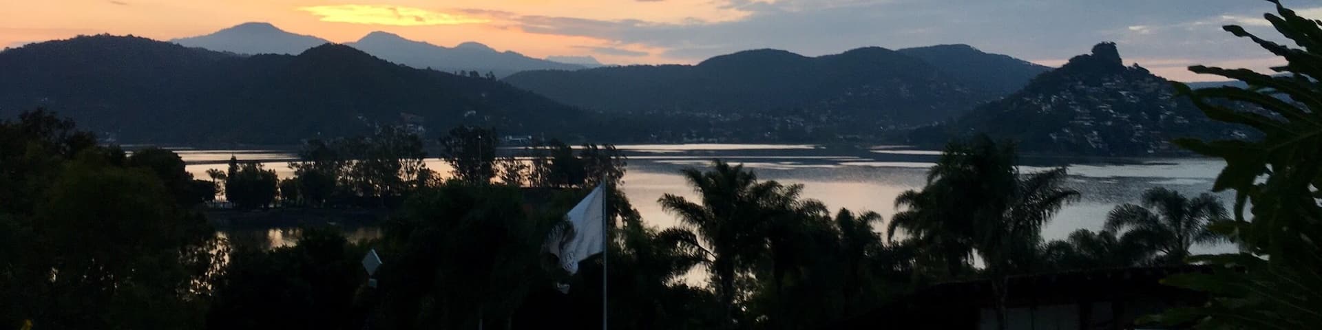 A sunset over a lake with mountains in the background.