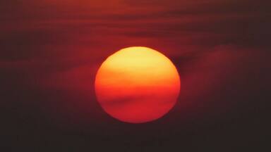 A sunset with a red-orange sun.