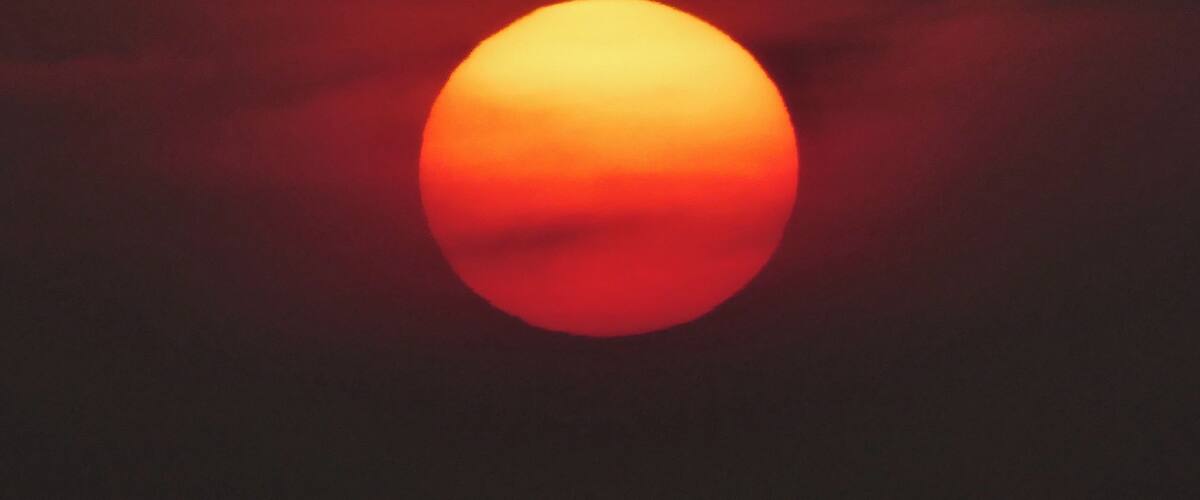 A sunset with a red-orange sun.