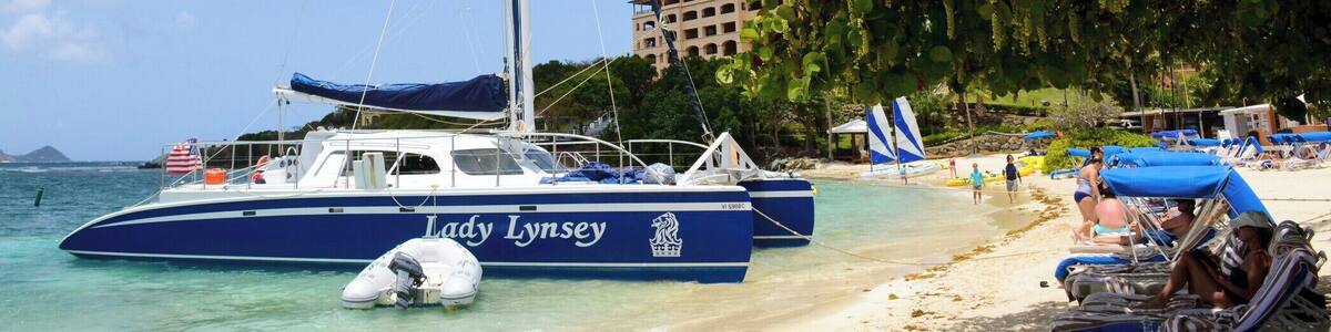 A beach with a sailboat named 'Lady Lynsey' anchored near the shore.