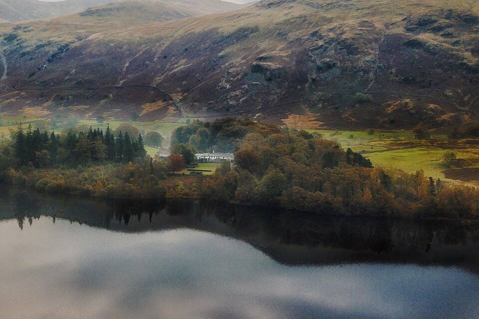 A lake surrounded by hills and a house in the valley.