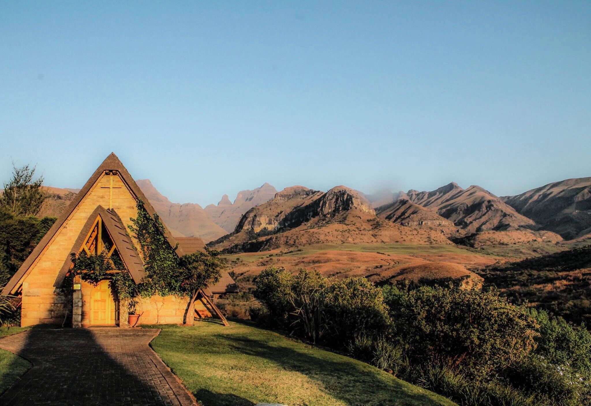 A stone house with a triangular roof in a hilly landscape.