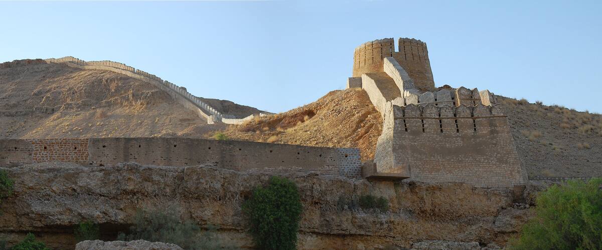 A large ancient stone wall with a tower.