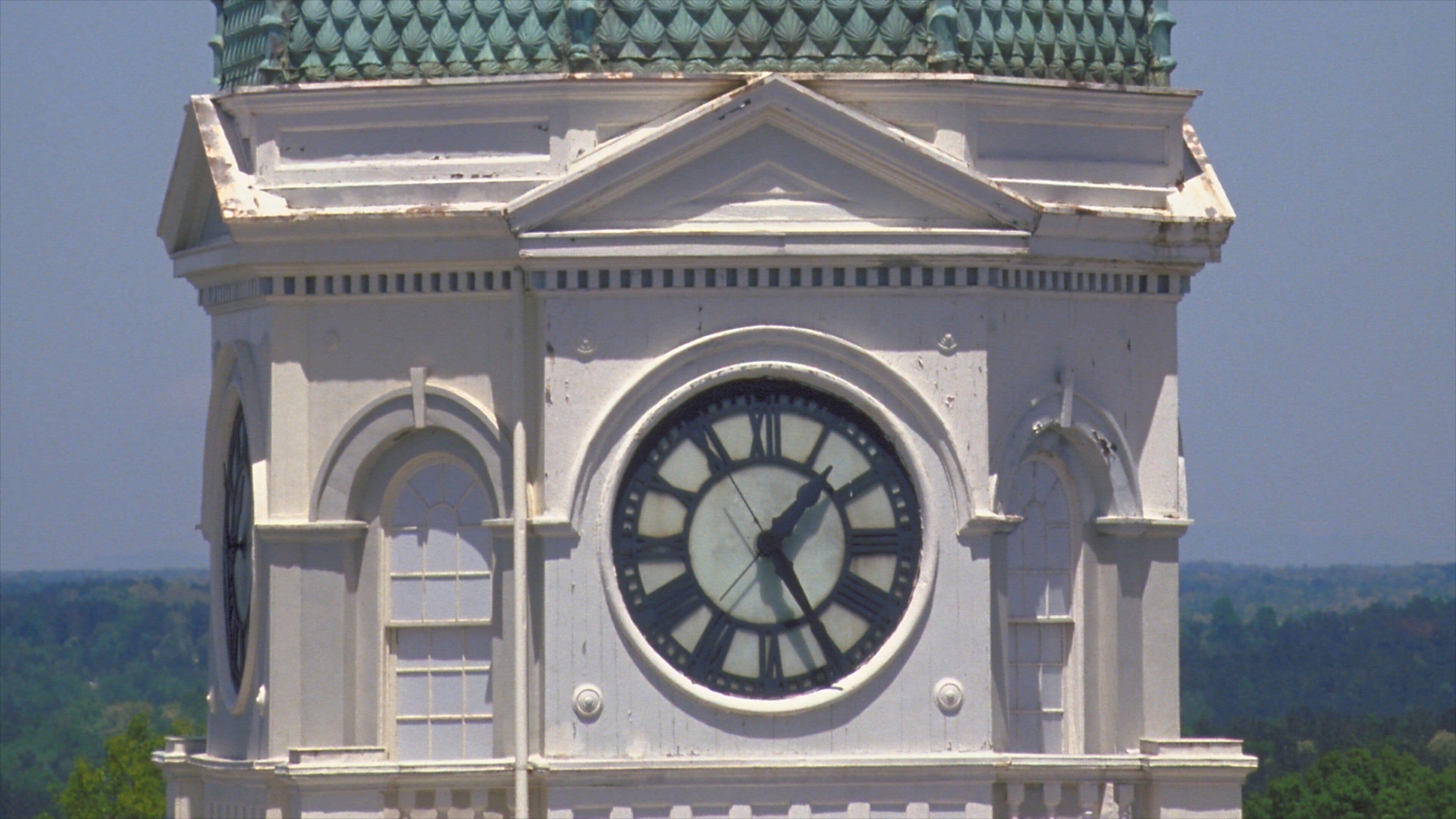 A clock tower with a large Roman numeral clock face, surrounded by classical architecture.