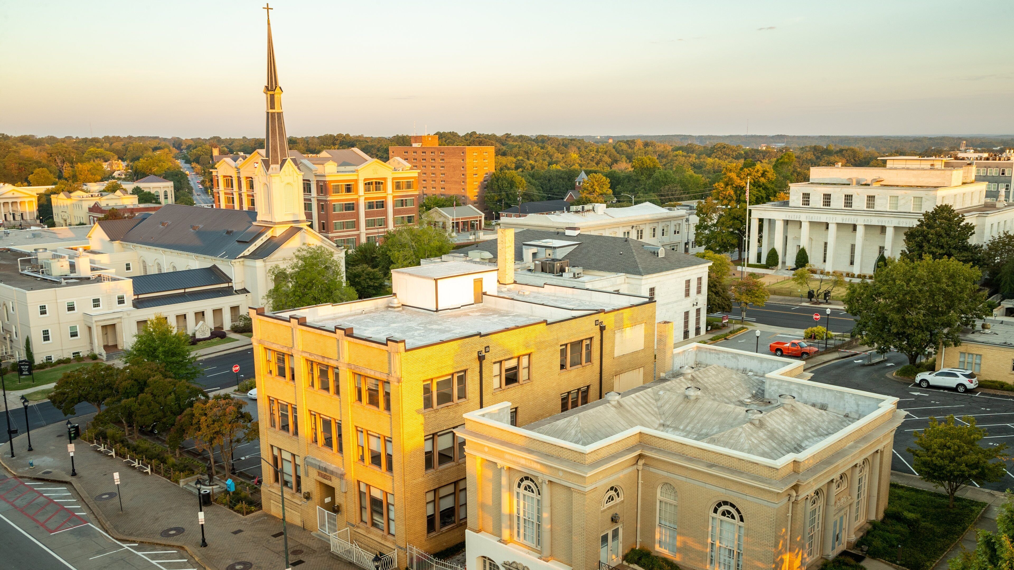 A cityscape with a prominent church steeple, a courthouse, and various buildings.