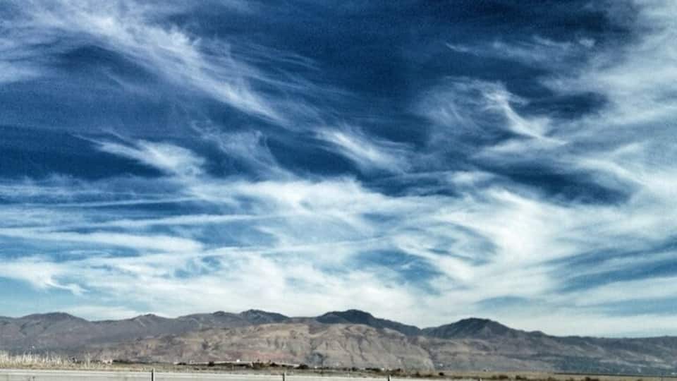 A desert landscape with mountains in the background and a clear sky.