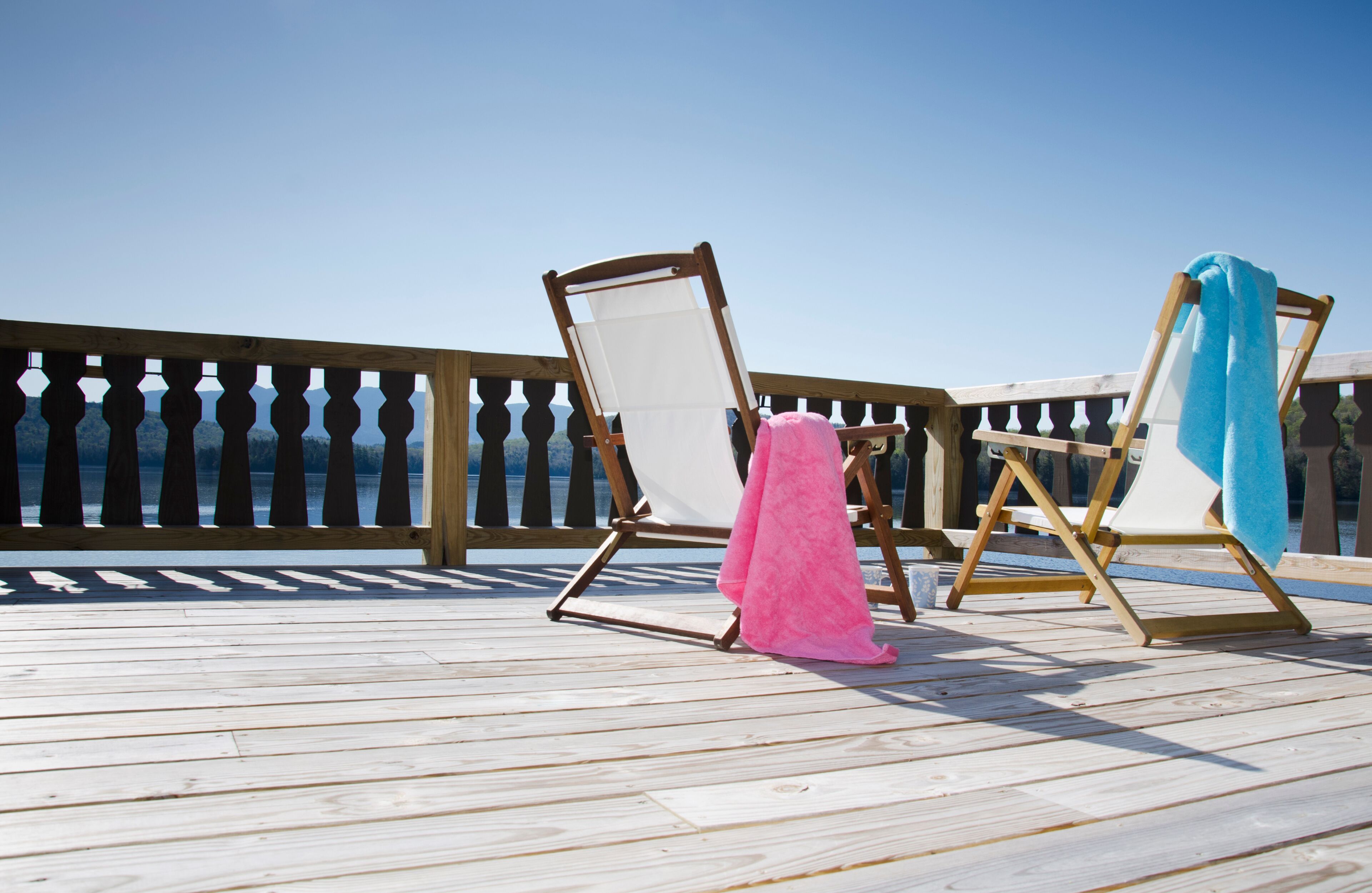 USA, New York, Lake Placid, Canvas chairs on deck overlooking lake