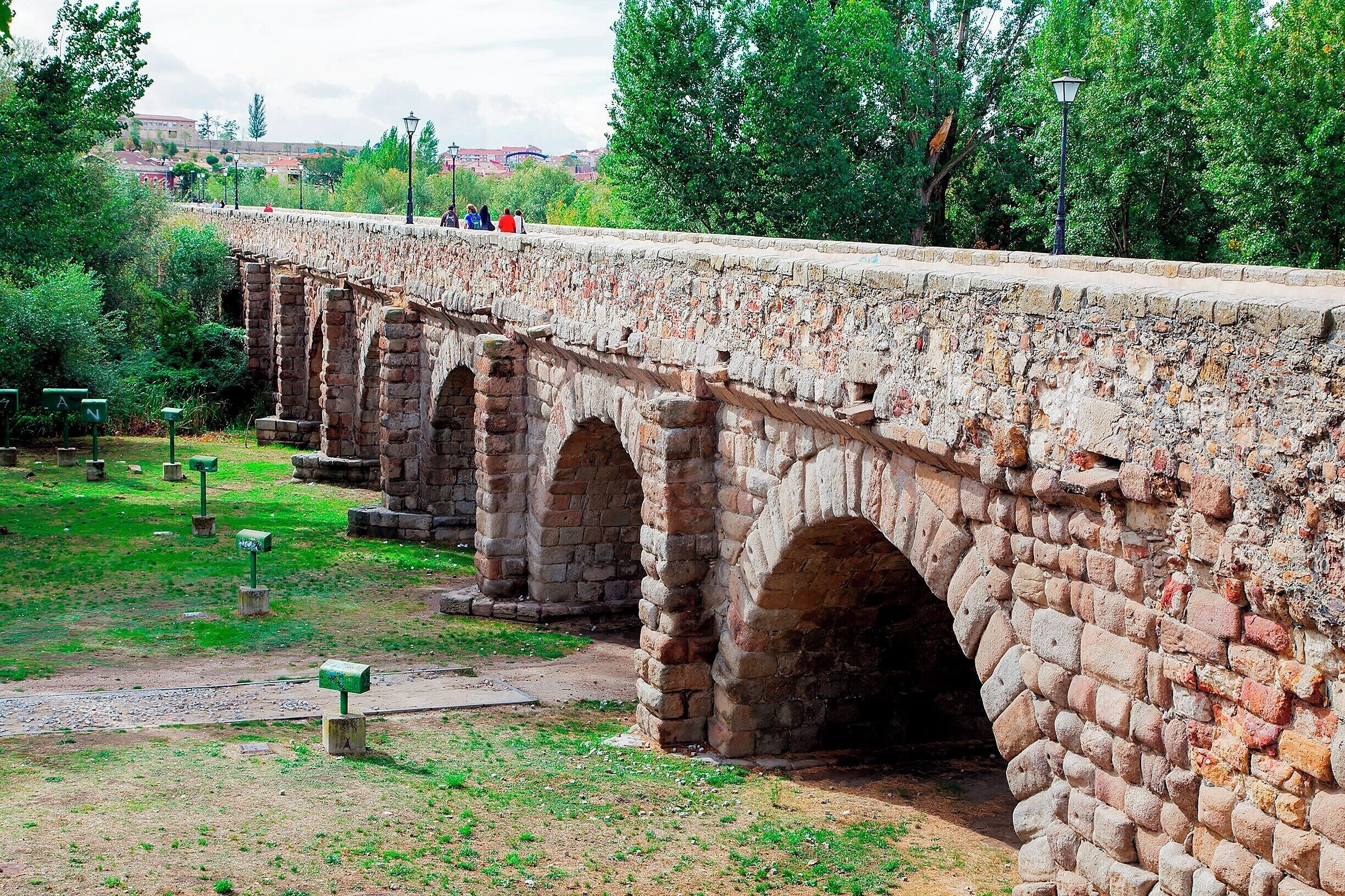 Attention: All vehicles over 18 tons use the Roman bridge.  Apparently that was the notice installed on the new Salamanca bridge when it opened in 1913.  The Roman's knew how to (over) engineer their bridges, which is why hundreds of them still stand all over Europe.

This particular bridge crosses the Tormes River along the Vía de la Plata, an historically important military and trade route in western Spain.  The bridge was built in 89 and features 15 arches spanning nearly a quarter mile (356m).  Some of the arches were rebuilt in 17th century after severe flooding.

Today the bridge is a pedestrian walkway and is nicely illuminated at night.  I guess modern day Salamancians finally figured out how to build a bridge for 18-ton trucks.
