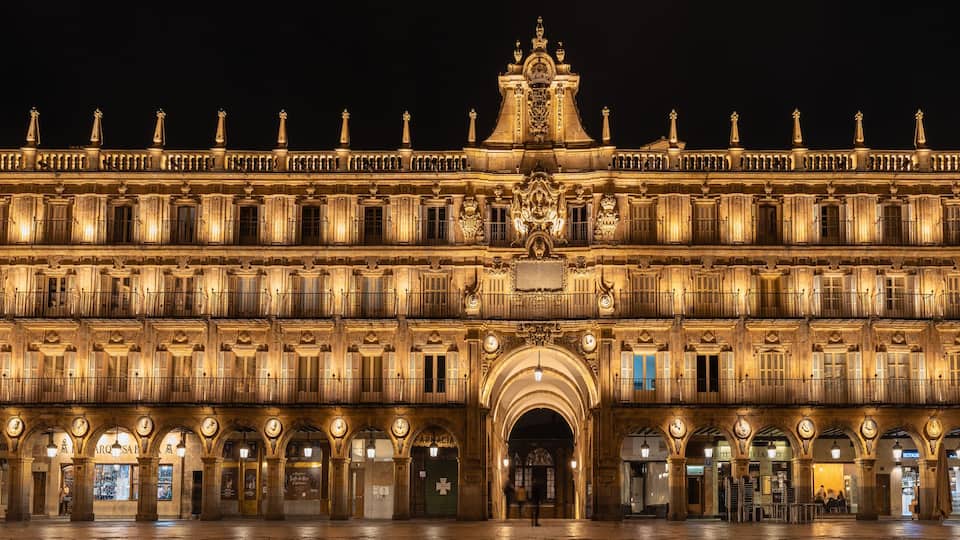 A grand illuminated building with multiple arches and balconies.