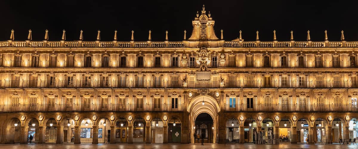 A grand illuminated building with multiple arches and balconies.