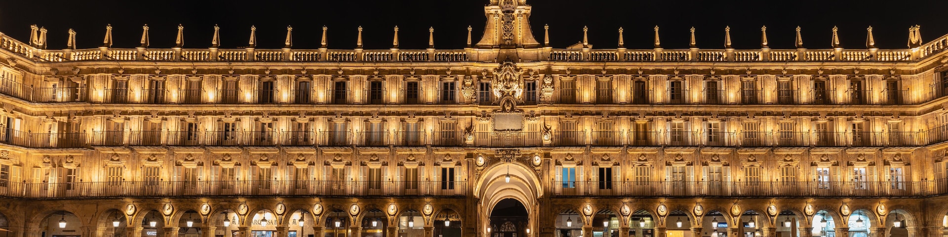 A grand illuminated building with multiple arches and balconies.