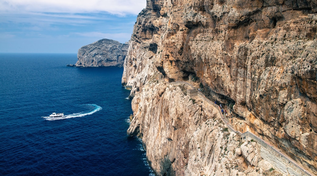 Stairway in limestone rock to stalactite Neptune cave. Boat leaving Grotte di Nettuno in Sardinia, Italy