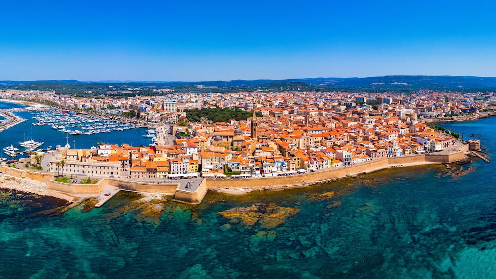 Aerial view over Alghero old town, cityscape Alghero view on a beautiful day with harbor and open sea in view. Alghero, Italy. Panoramic aerial view of Alghero, Sardinia, Italy.