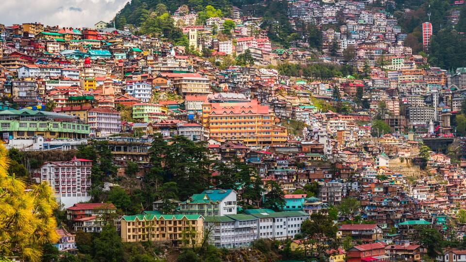 A densely packed hillside town with colorful buildings and lush greenery.