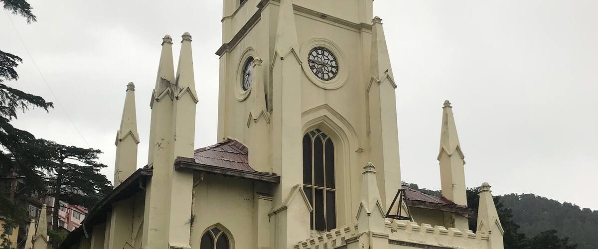A historic church with a tall bell tower and arched windows.